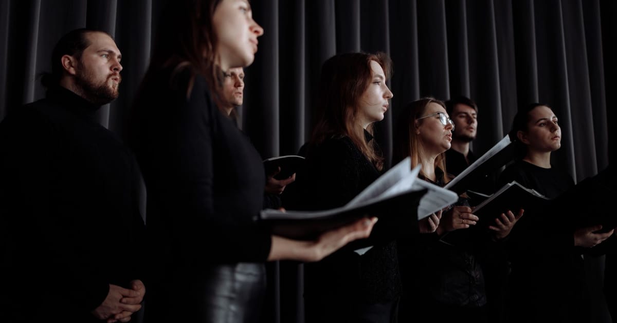 Paduan suara bernyanyi berbaris sambil memegang partitur