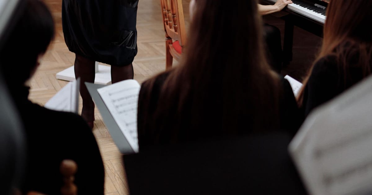 Latihan paduan suara dengan iringan piano di dalam ruangan