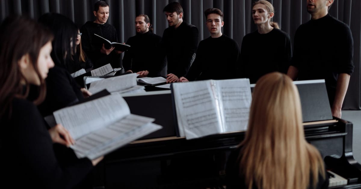 Paduan suara berlatih dengan partitur di atas stan musik